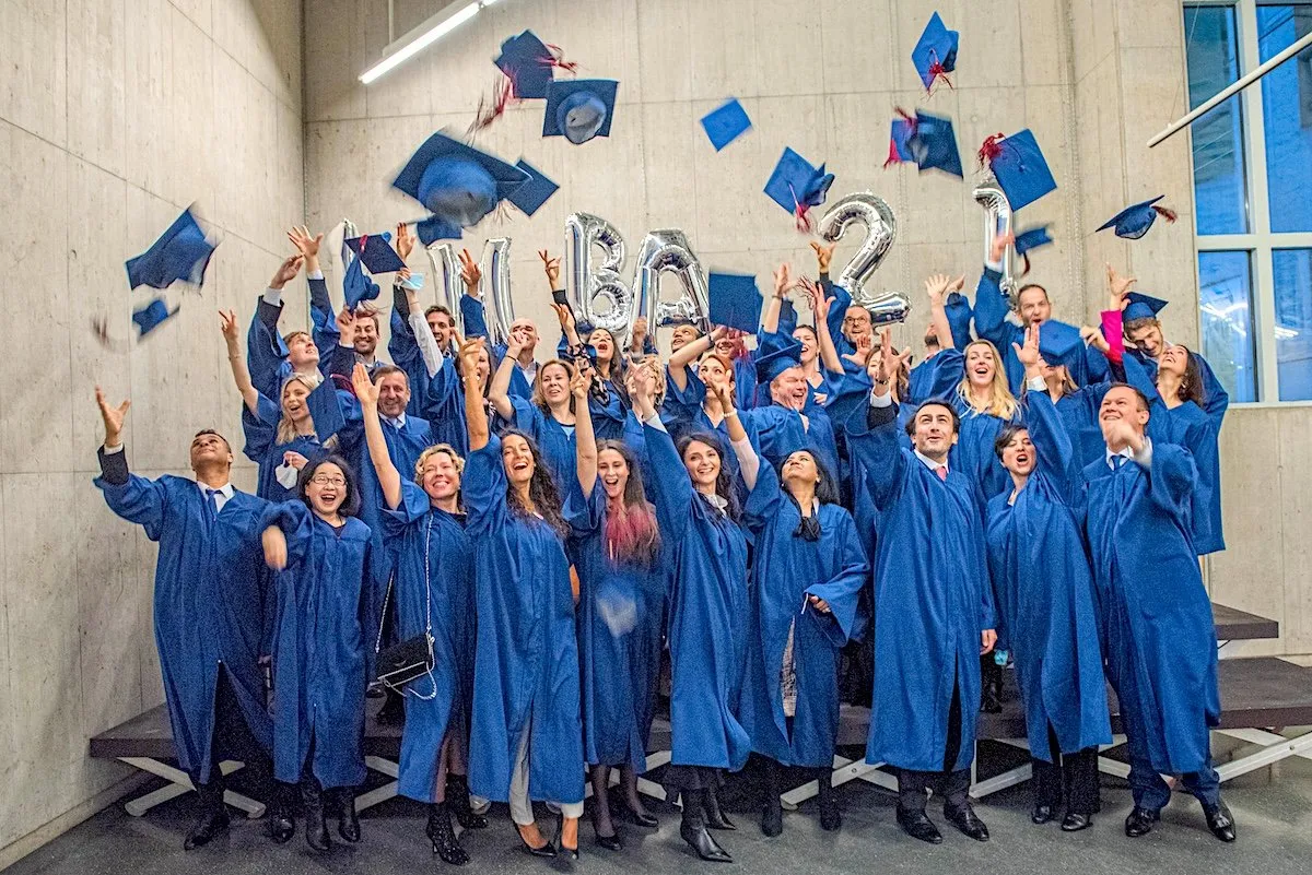 The EMBA Class of 2021 throwing their caps in the air after graduation
