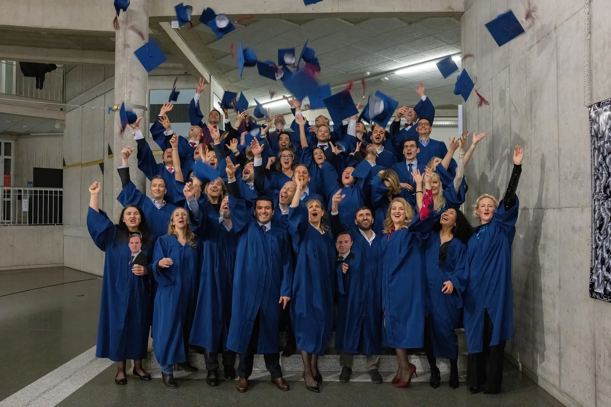 The EMBA Class of 2022 throwing their caps in the air after graduation