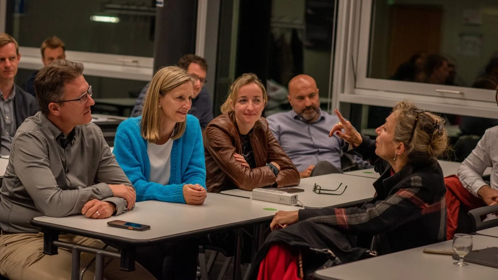 EMBA participants in discussion around tables during a class session