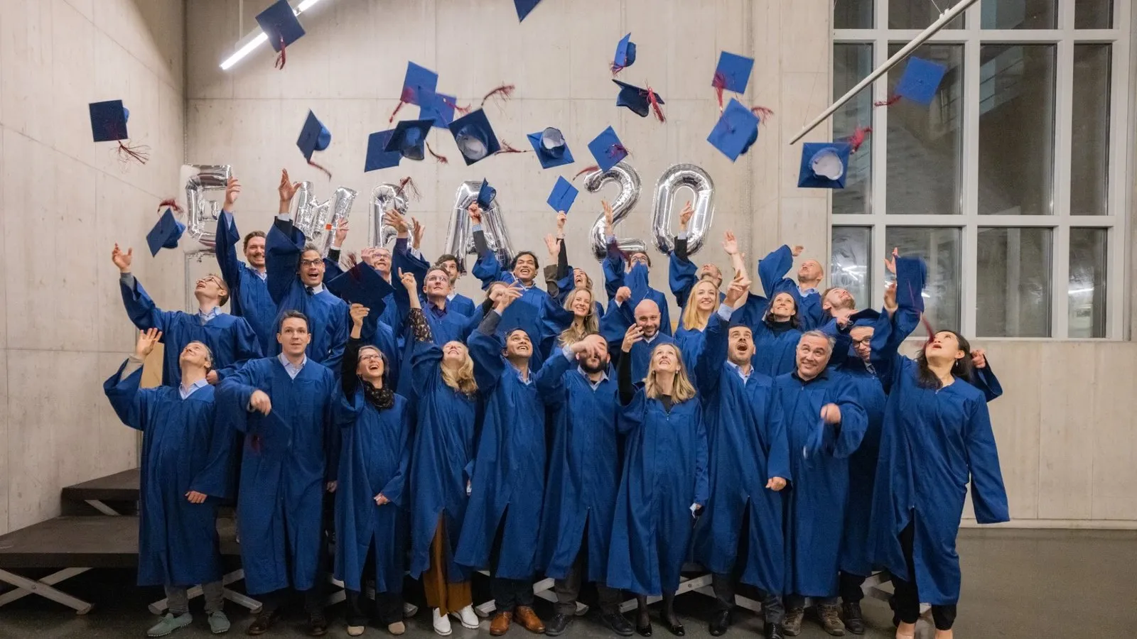 HEC Lausanne Executive MBA graduates throwing their caps in the air