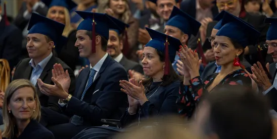 Diplômé·e·s de l’Executive MBA en toge et mortier applaudissant lors de la cérémonie de remise des diplômes 2024