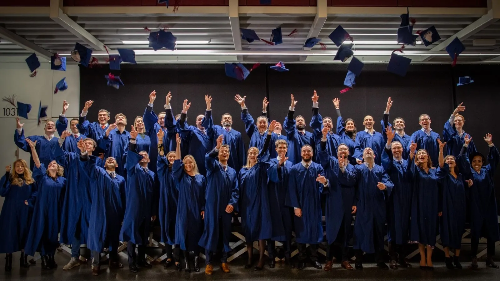 The EMBA Class of 2019 throwing their caps in the air at graduation