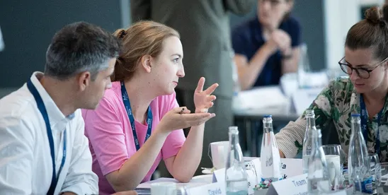 EMBA participants exchanging ideas around a table during the introduction week